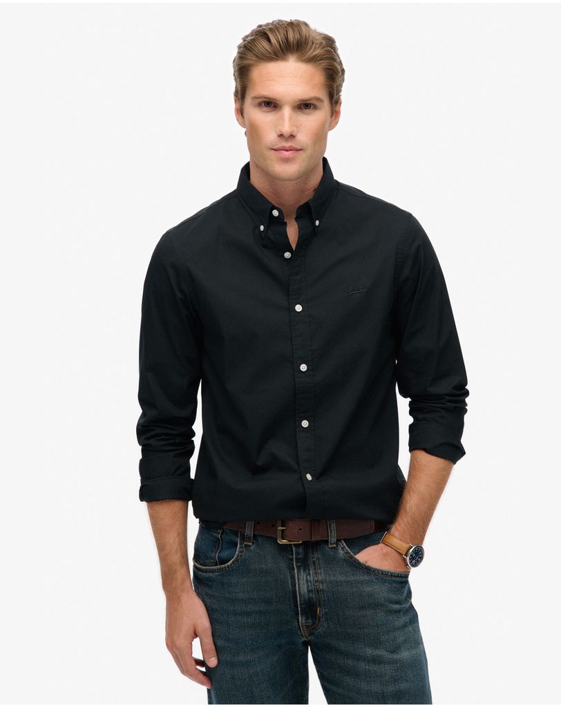 Model wearing a black button shirt on a white studio background
