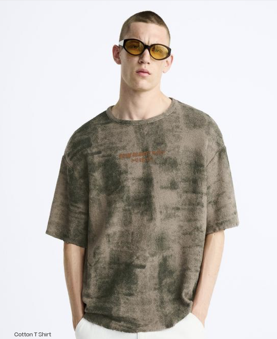 Model wearing a cream tee and orange cap on a white studio background
