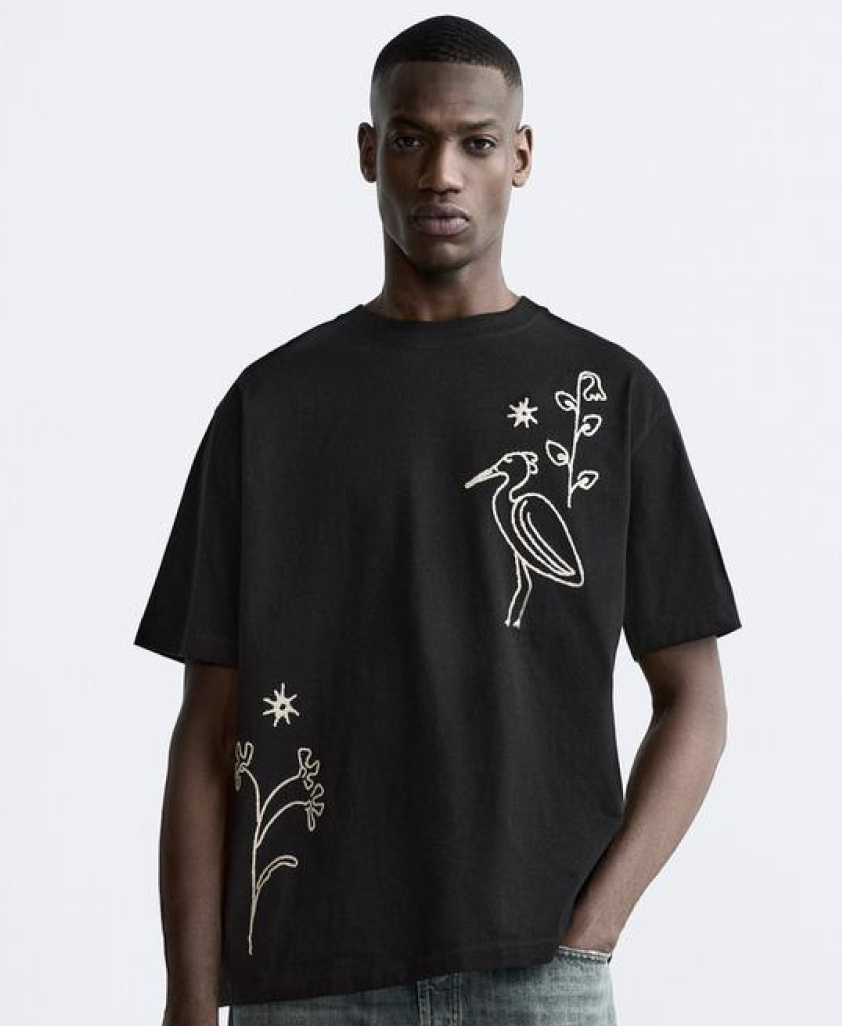 Model wearing a black and white abstract print shirt on a white studio background
