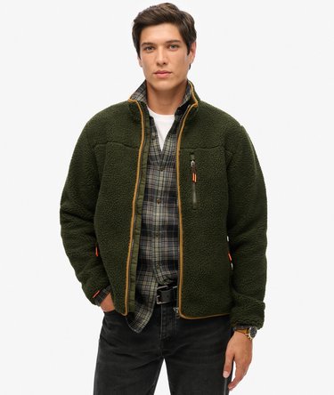 Model wearing a green fleece jacket on a white studio background