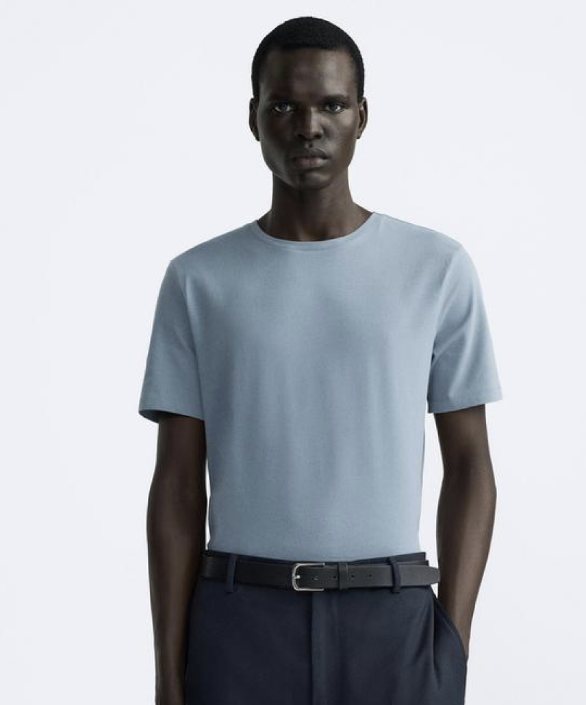 Model wearing a black heavy weight t-shirt and sunglasses on a white studio background