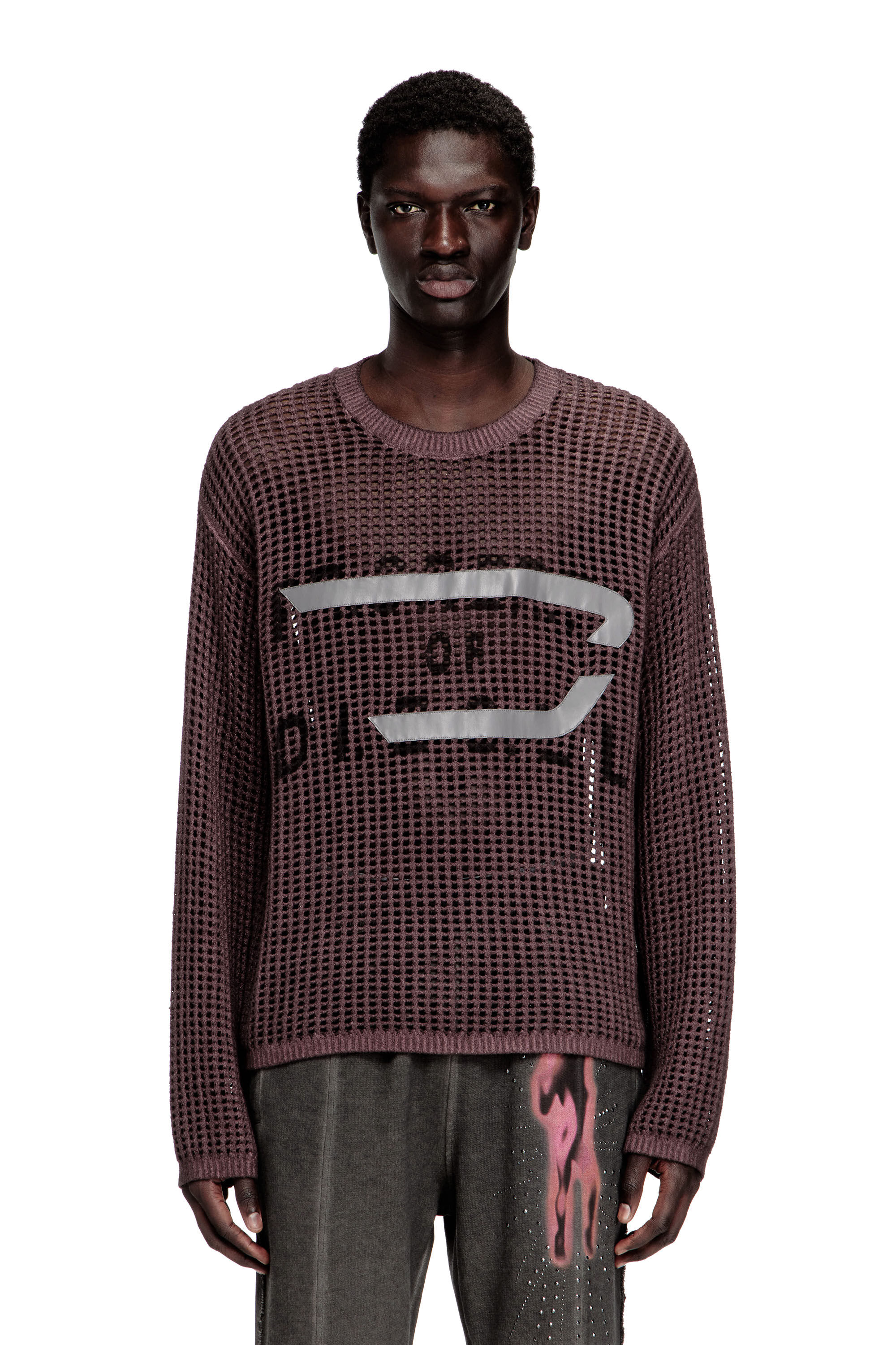 Model wearing a mesh sweater on a white studio background