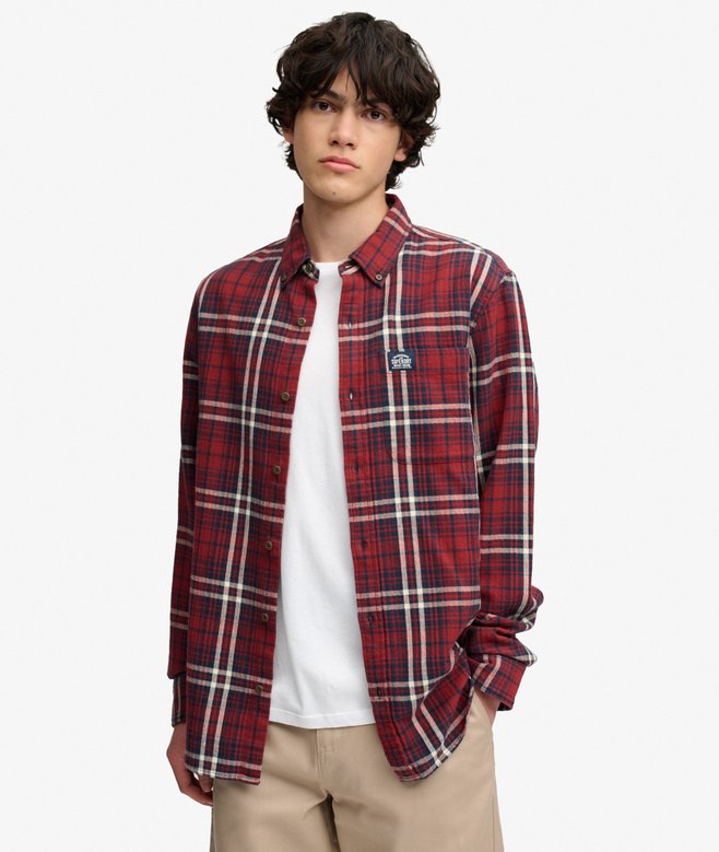 Model wearing a red plaid overshirt on a white studio background