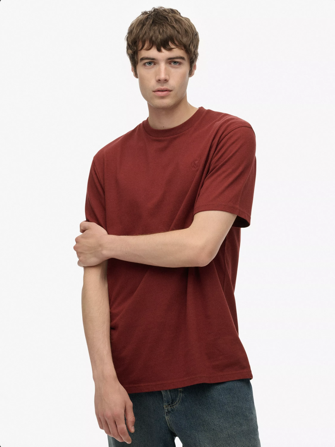 Model wearing a red t-shirt on a white studio background