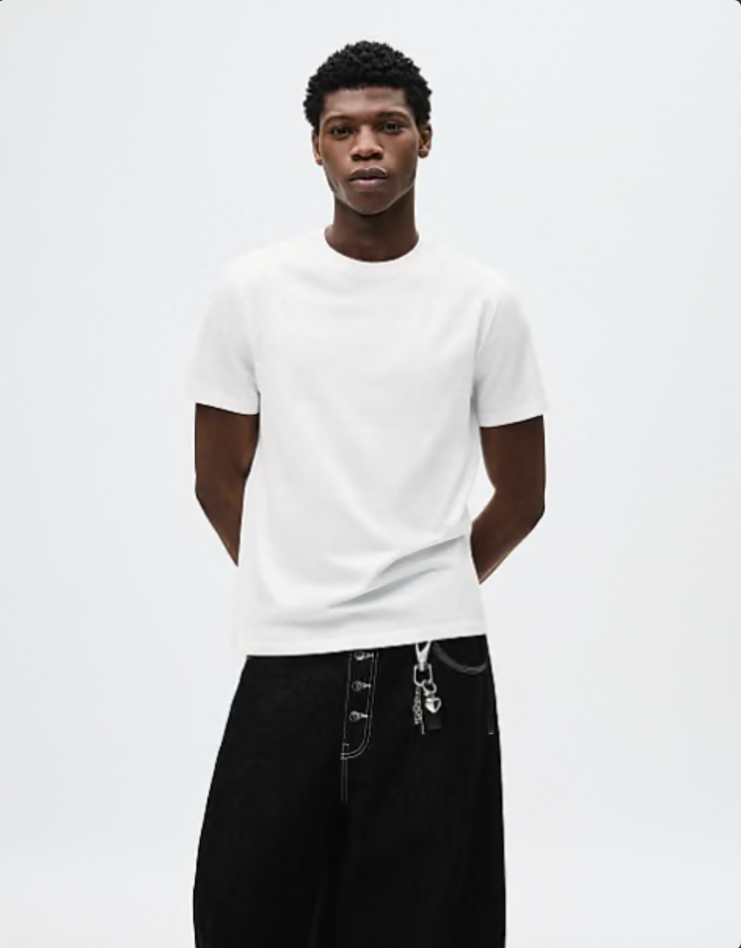 Model wearing a white t-shirt on a white studio background